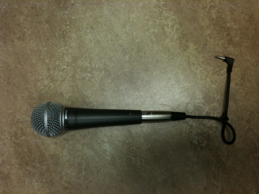 A Shure SM48 dynamic microphone attached to a high-impedance/low-impedance transformer